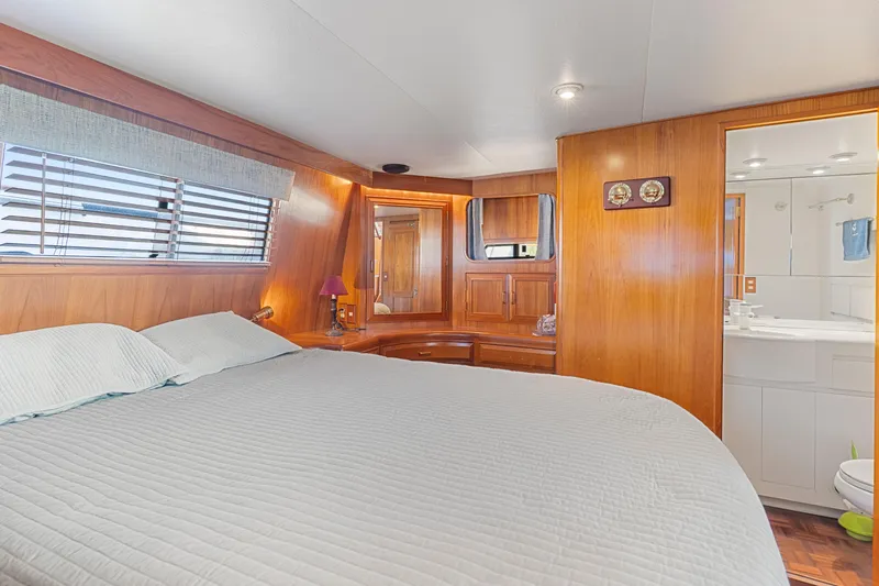Slide: The Image of Luxurious 1993 Ocean Alexander 440 yacht bedroom with wood paneling and ensuite bathroom. - 27