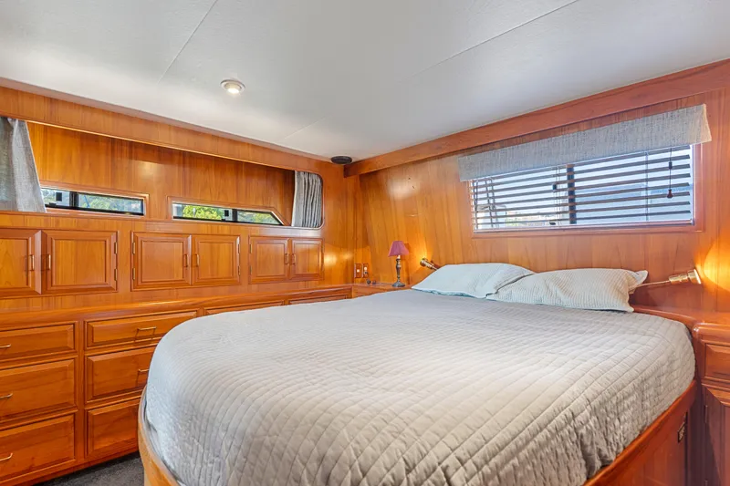 Slide: The Image of Luxurious 1993 Ocean Alexander 440 yacht bedroom with wood paneling and cozy bedding. - 28