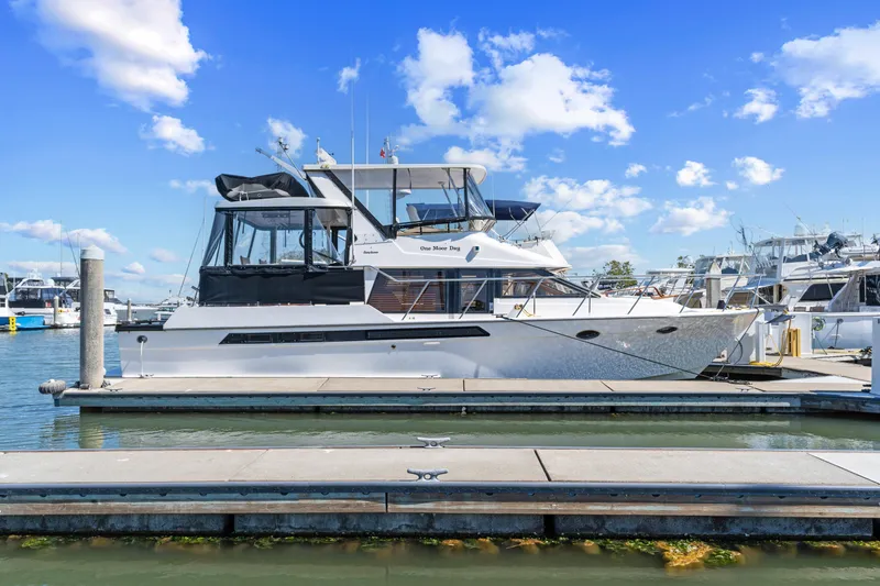 Slide: The Image of 1993 Ocean Alexander 440 yacht docked at marina under blue sky. - 3