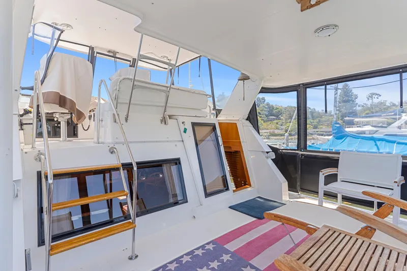 Slide: The Image of 1993 Ocean Alexander 440 yacht interior with seating, stairs, and American flag rug. - 6
