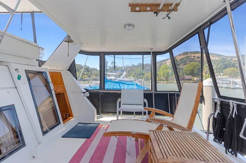 Slide: The Image of 1993 Ocean Alexander 440 yacht interior with seating, table, and scenic marina view. - 7