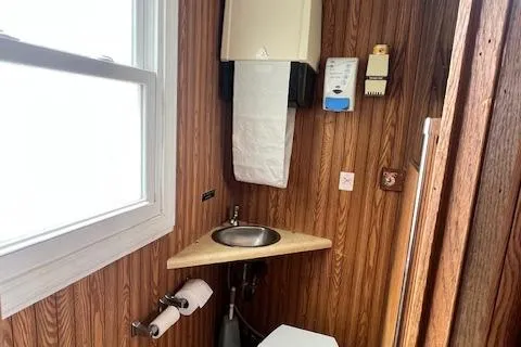 Slide: The Image of Wood-paneled interior of a 1984 Skipperliner 54, featuring a closed door and staircase. - 10