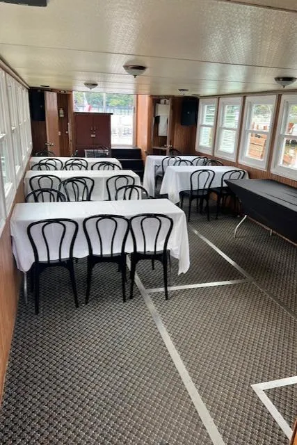 Slide: The Image of Interior of 1984 Skipperliner 54 with tables, chairs, and large windows. - 4