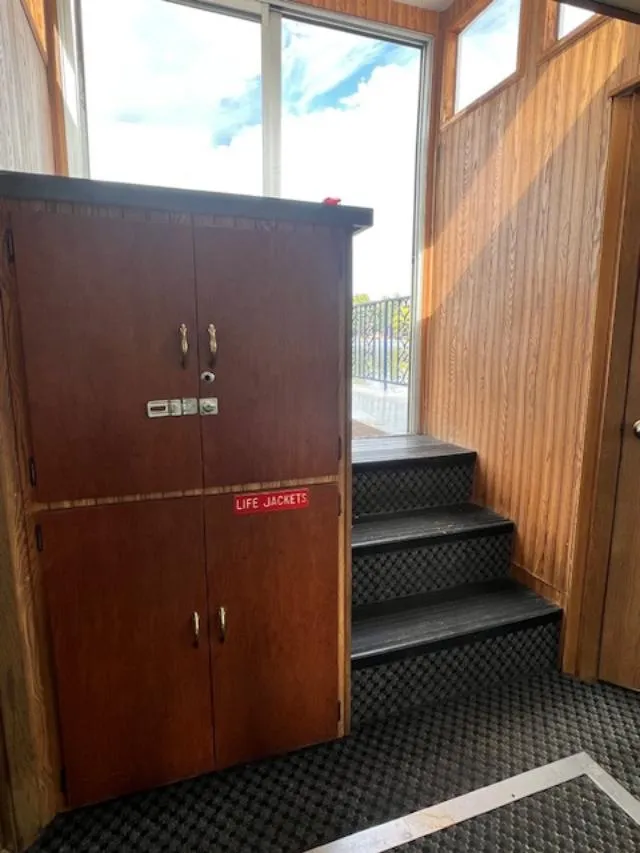 Slide: The Image of Interior of 1984 Skipperliner 54 with dining tables and chairs, white tablecloths, and windows. - 5