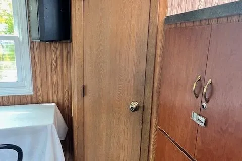 Slide: The Image of Interior of 1984 Skipperliner 54 with wooden cabinet and stairs, labeled "Life Jackets." - 6