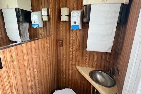 Slide: The Image of 1984 Skipperliner 54 bathroom with wood paneling, sink, and toilet. - 8