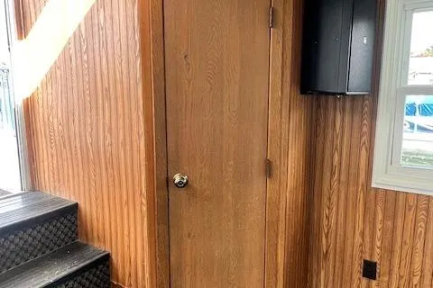 Slide: The Image of 1984 Skipperliner 54 bathroom with wood paneling, sink, and paper towel dispensers. - 9