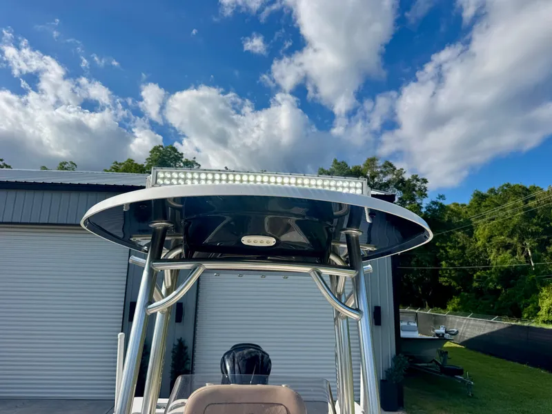 Slide: The Image of 2020 Sportsman Open 232 Center Console boat with T-top and LED lights under a blue sky. - 10