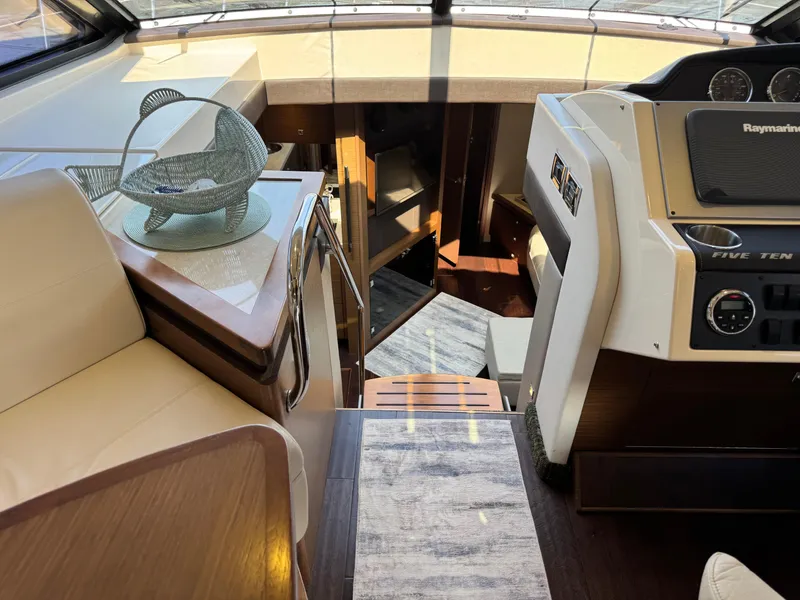 Slide: The Image of Interior of 2014 Sea Ray 510 Sundancer yacht, featuring helm and seating area. - 14