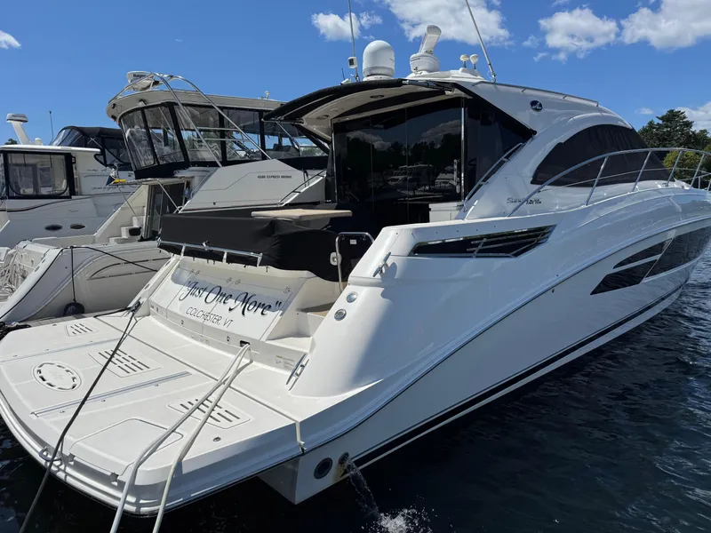 Slide: The Image of 2014 Sea Ray 510 Sundancer yacht docked, featuring sleek design and spacious deck. - 4