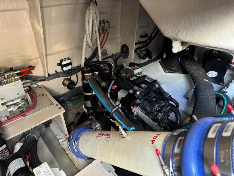 Slide: The Image of Engine room of 2014 Sea Ray 510 Sundancer with visible mechanical components and hoses. - 47