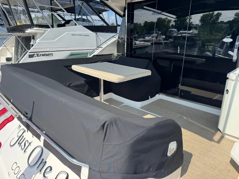 Slide: The Image of 2014 Sea Ray 510 Sundancer yacht with covered seating and table on deck. - 6