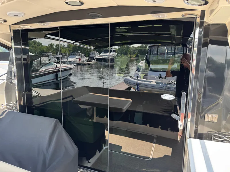 Slide: The Image of 2014 Sea Ray 510 Sundancer yacht interior with marina view through glass doors. - 8