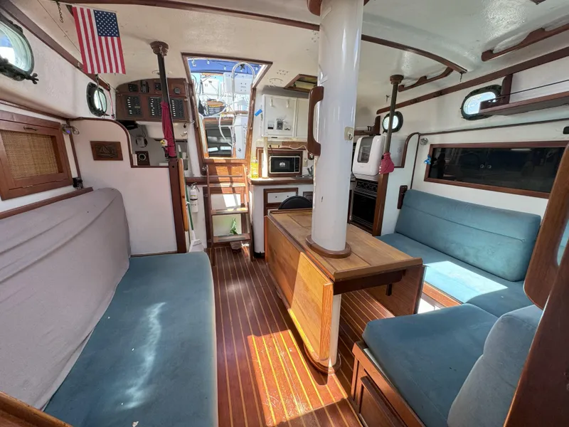 Slide: The Image of Interior of a 1979 CSY 44 sailboat with wooden furnishings and blue seating. - 11