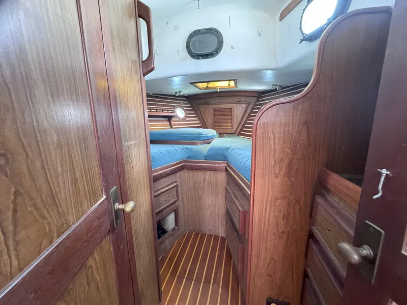 Slide: The Image of 1979 CSY 44 sailboat interior with wooden cabinetry and blue bedding. - 17