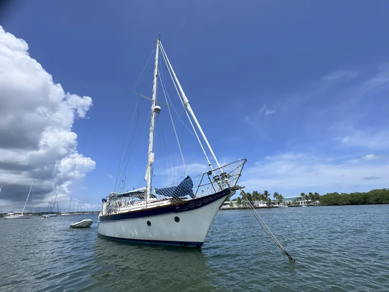 Slide: The Image of Sailboat CSY 44 from 1979 anchored in calm waters under a clear blue sky. - 2
