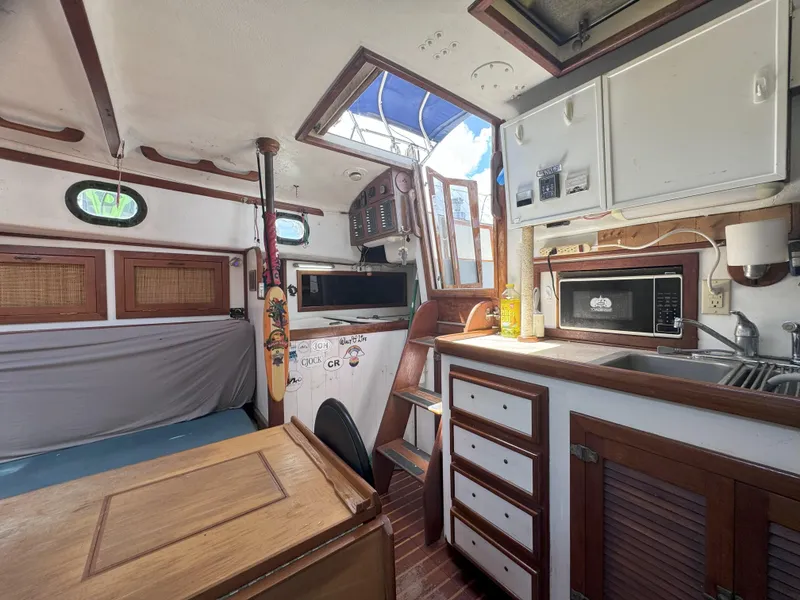 Slide: The Image of 1979 CSY 44 yacht interior with kitchen, wooden cabinets, and nautical decor. - 20