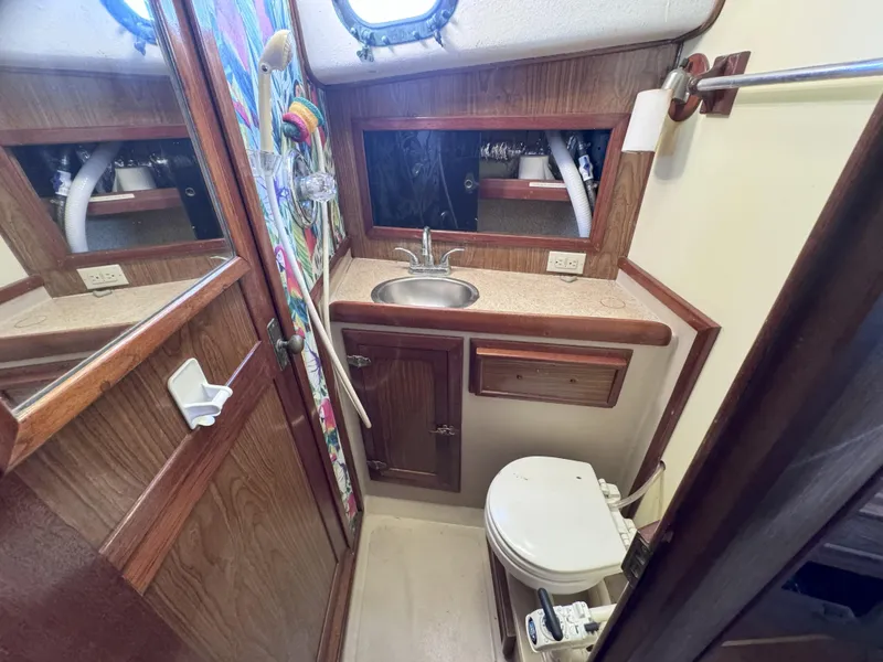 Slide: The Image of 1979 CSY 44 yacht bathroom with sink, toilet, and wooden cabinetry. - 22