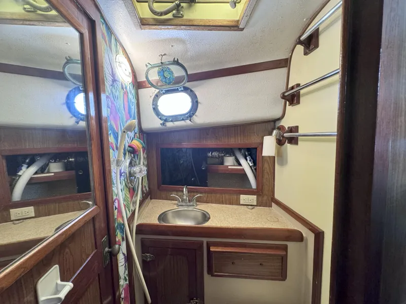 Slide: The Image of 1979 CSY 44 yacht bathroom with sink, mirror, and colorful wall art. - 24