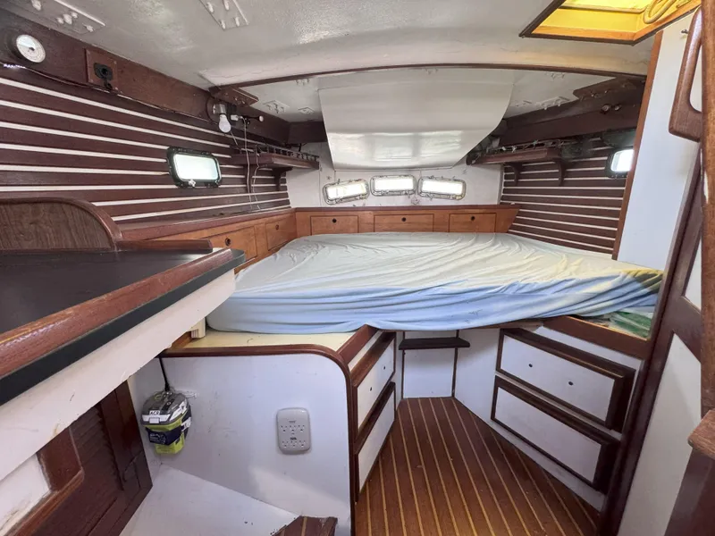 Slide: The Image of Interior of a 1979 CSY 44 sailboat cabin with wood paneling and a bed. - 25