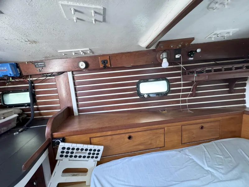 Slide: The Image of 1979 CSY 44 yacht interior with wooden cabinetry and porthole window. - 28