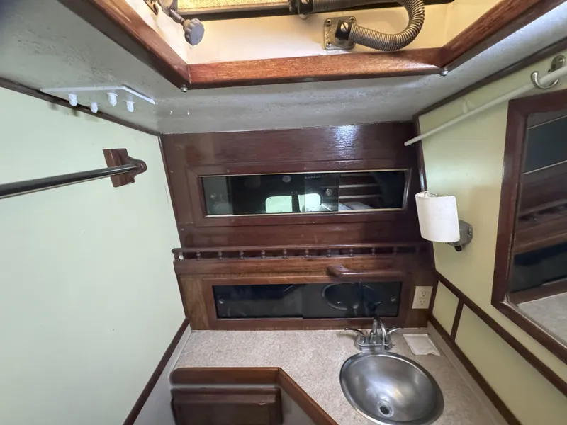 Slide: The Image of 1979 CSY 44 yacht bathroom with sink, mirror, and wooden accents. - 29