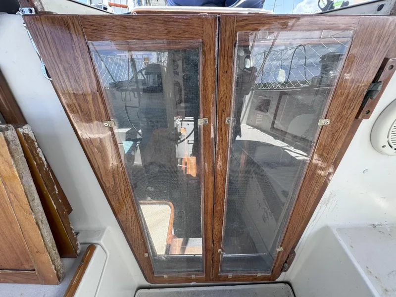Slide: The Image of Wooden cabin doors on a 1979 CSY 44 sailboat, featuring glass panels and nautical design. - 30