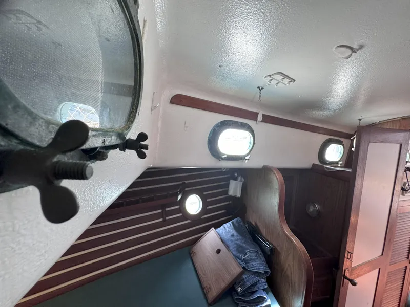 Slide: The Image of Interior of a 1979 CSY 44 sailboat cabin with portholes and wooden accents. - 35