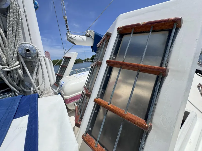 Slide: The Image of 1979 CSY 44 sailboat deck with ropes and wooden railings under clear sky. - 37