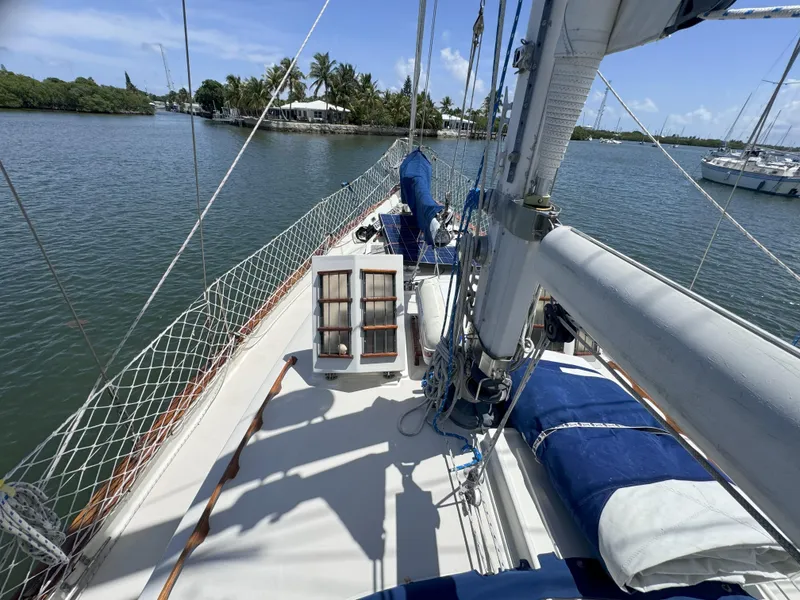 Slide: The Image of 1979 CSY 44 sailboat deck with rigging, docked in a serene marina. - 5