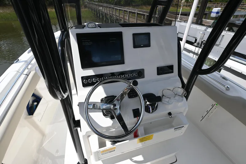 Slide: The Image of 2024 Key West 239 FS boat dashboard with steering wheel and navigation controls. - 12