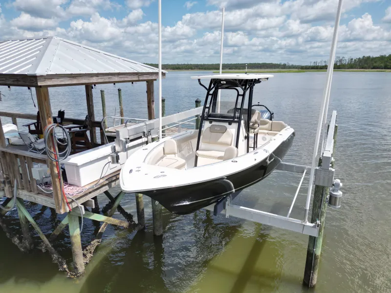 Slide: The Image of 2024 Key West 239 FS boat on lift by dock, under cloudy sky. - 2
