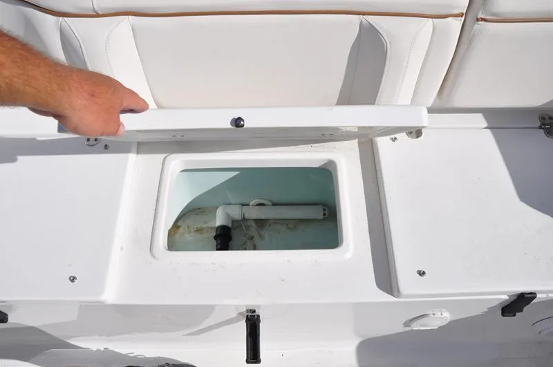 Slide: The Image of 2020 Sea Hunt Ultra 225 boat storage compartment with open lid and visible plumbing. - 11