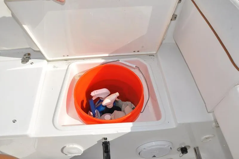Slide: The Image of Storage compartment on 2020 Sea Hunt Ultra 225 with cleaning supplies in an orange bucket. - 12