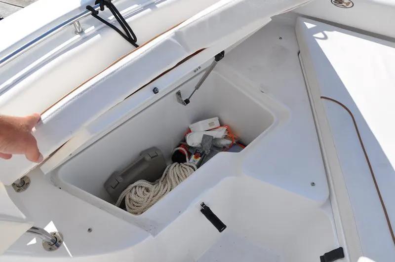Slide: The Image of Storage compartment on a 2020 Sea Hunt Ultra 225 boat, containing rope and equipment. - 24