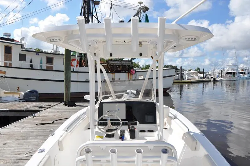 Slide: The Image of 2020 Sea Hunt Ultra 225 boat docked at marina, featuring center console and T-top. - 5
