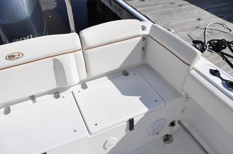 Slide: The Image of 2020 Sea Hunt Ultra 225 boat interior with white seating and storage compartments. - 9