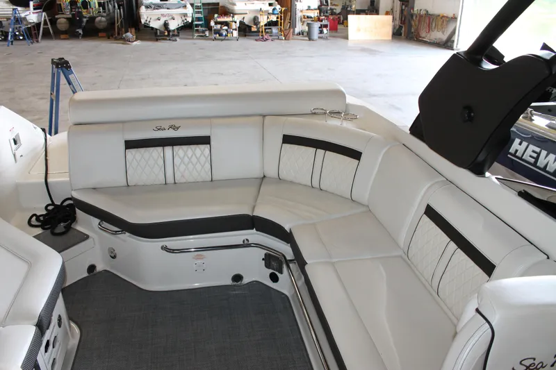 Slide: The Image of 2018 Sea Ray 280 SLX boat interior with white leather seating in a spacious garage. - 12