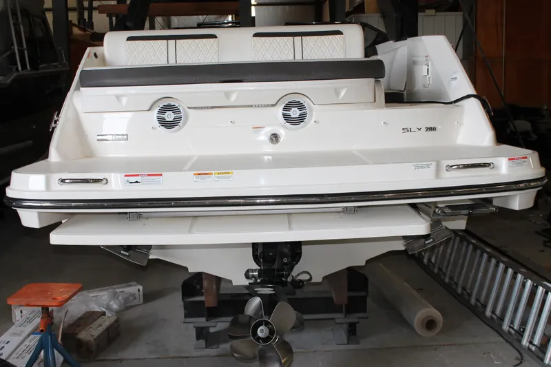 Slide: The Image of 2018 Sea Ray 280 SLX boat rear view in storage, showcasing swim platform and propeller. - 3