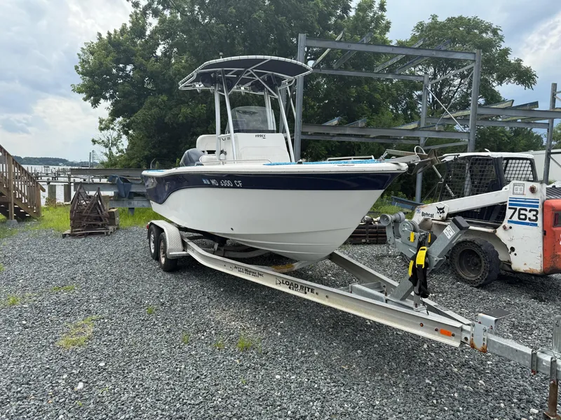 Slide: The Image of 2013 Sea Fox 199 Commander boat on trailer, parked outdoors near trees and equipment. - 3