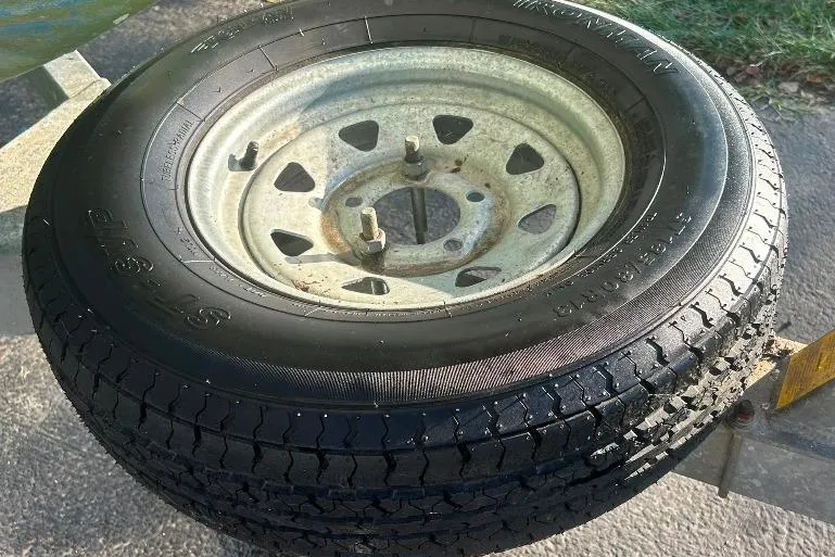Slide: The Image of Trailer tire and wheel for 2002 Bayliner 184 SF boat, shown on pavement. - 17