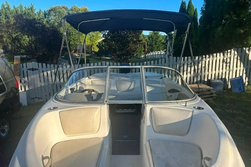 Slide: The Image of 2002 Bayliner 184 SF boat with canopy, parked in a yard with white fence. - 20