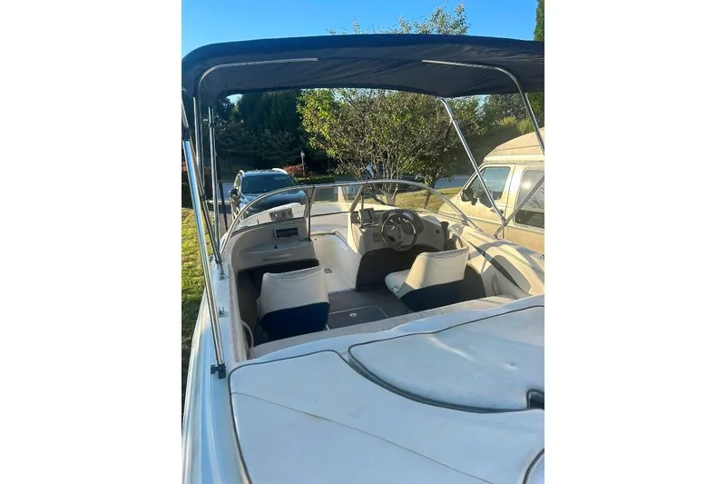 Slide: The Image of 2002 Bayliner 184 SF boat interior with canopy, steering wheel, and seating. - 21