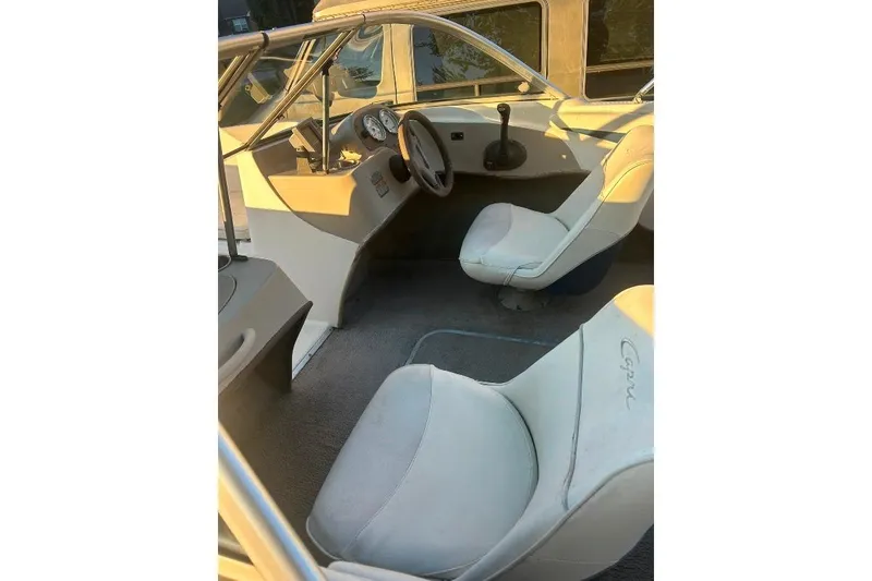 Slide: The Image of 2002 Bayliner 184 SF boat interior with steering wheel and white seats. - 25