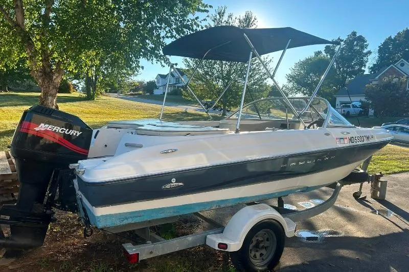 Slide: The Image of 2002 Bayliner 184 SF boat on trailer with Mercury outboard motor, parked outdoors. - 3