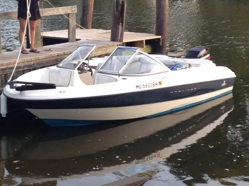 Slide: The Image of 2002 Bayliner 184 SF boat docked on calm water near a wooden pier. - 4