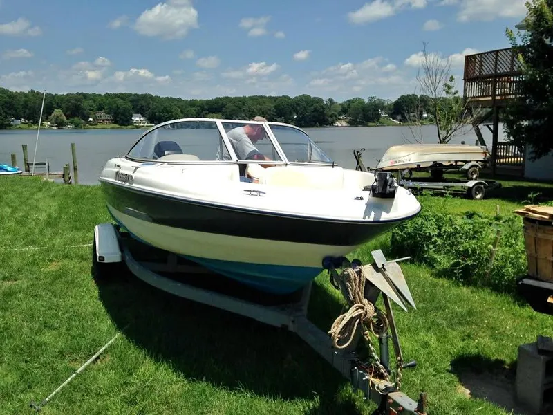 Slide: The Image of 2002 Bayliner 184 SF boat on trailer by a lakeside, under a clear sky. - 5