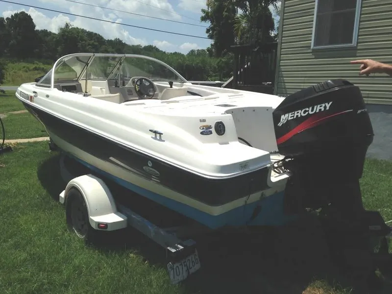 Slide: The Image of 2002 Bayliner 184 SF boat with Mercury outboard motor on trailer, parked on grass. - 7