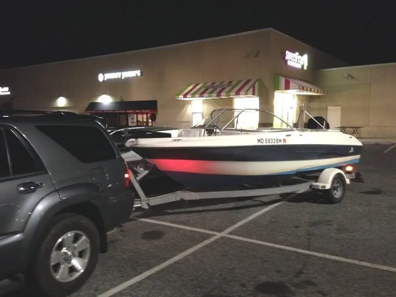Slide: The Image of SUV towing a 2002 Bayliner 184 SF boat in a parking lot at night. - 8