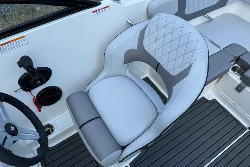 Slide: The Image of 2025 Bayliner VR4 Bowrider OB interior with steering wheel and cushioned seat. - 12